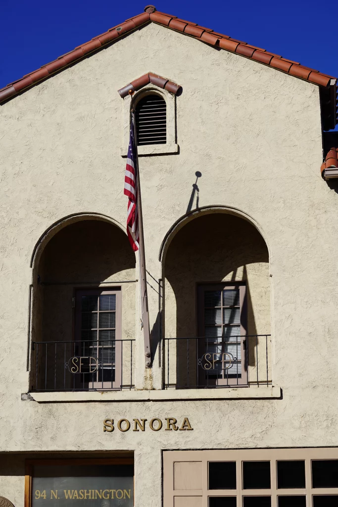 Fassade mit Balkonen und amerikanischer Flagge an einem Gebäude mit der Aufschrift „Sonora“ in Mariposa, Kalifornien