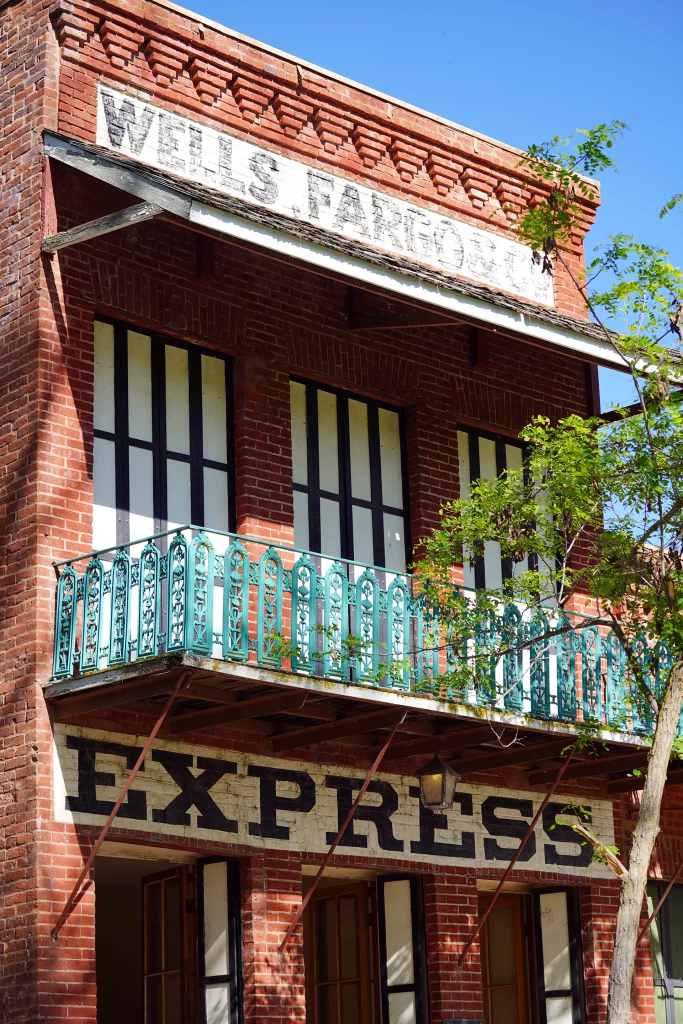 Historisches Backsteingebäude der Wells Fargo Express Company mit grünem Balkon in Columbia, Kalifornien.