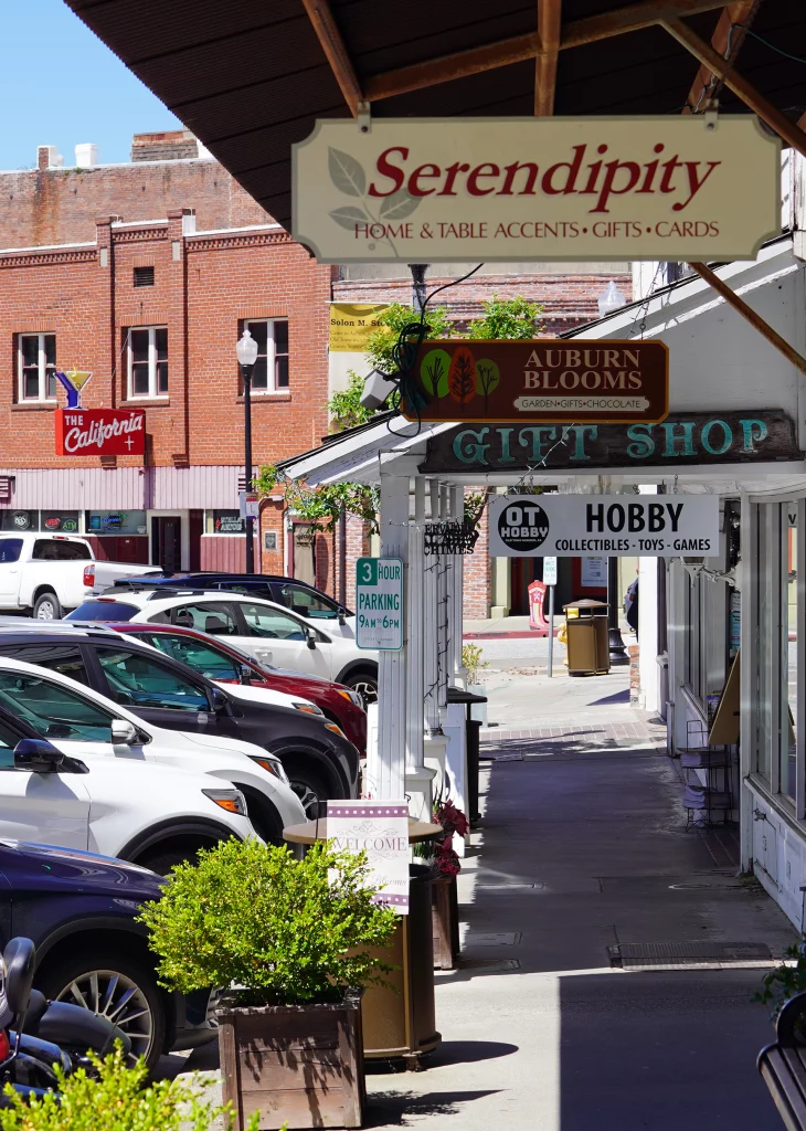 Schattiger Gehweg mit Shops und Parkplätzen in der historischen Altstadt von Placerville, Kalifornien
