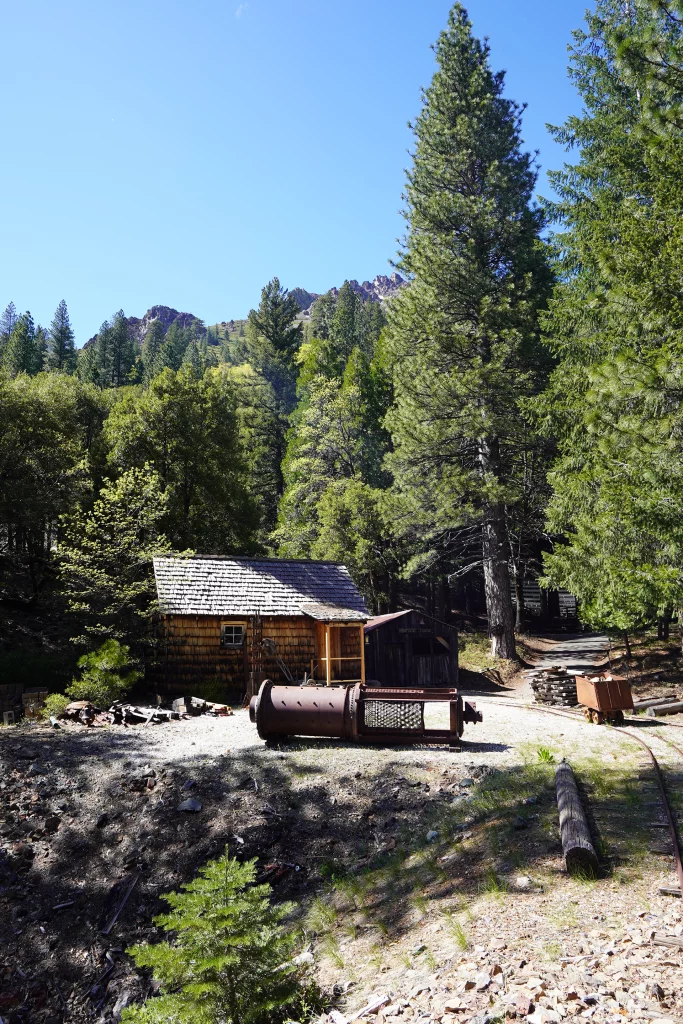 Blick auf historische Holzhütten und Bergbaurelikte im Freilichtmuseum der Kentucky Portal Mine inmitten der Wälder von Sierra City.
