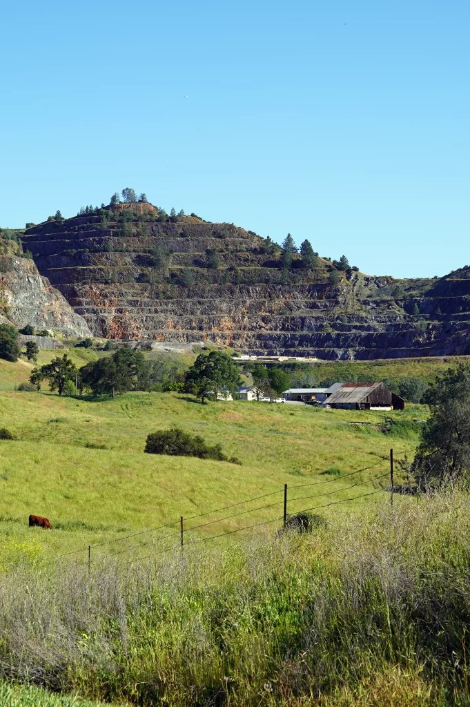 Blick auf den gestuften Tagebau bei Carson Hill mit angrenzender Farm im Vordergrund.