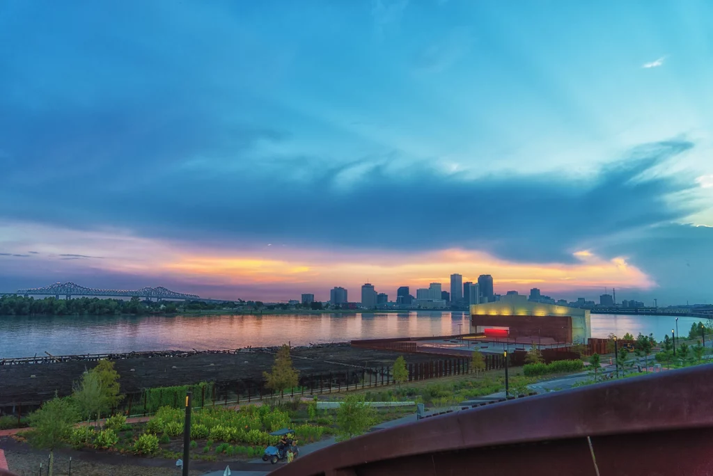 Skyline von New Orleans bei Sonnenuntergang mit Blick vom Crescent Park über den Mississippi.