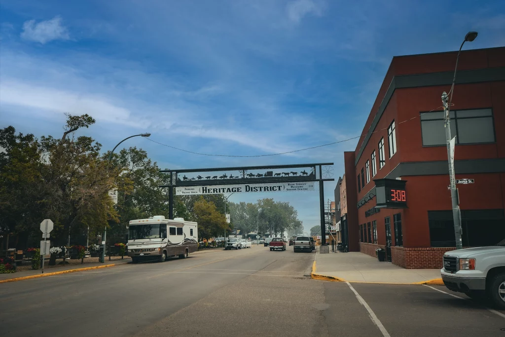 Blick auf die Heritage District Main Street von Maple Creek mit dem Straßenschild „Heritage District“ und geparktem Wohnmobil.