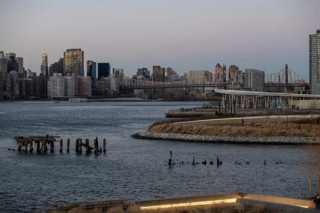 Blick auf den East River mit Manhattan-Skyline und Queensboro Bridge vom Hunters Point in Queens bei Sonnenuntergang.