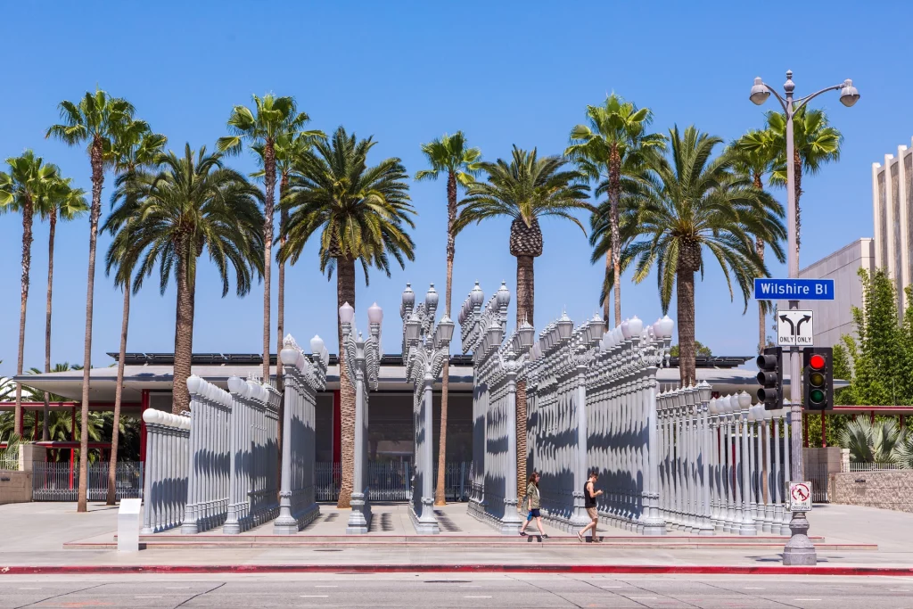 Urban Light installation at LACMA with palm trees and a clear blue sky in Los Angeles.