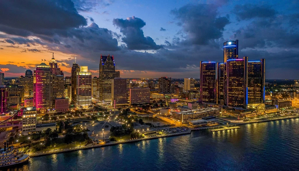 Die Skyline von Detroit bei Nacht, farbig illuminiert mit Blick auf das Renaissance Center am Detroit River.