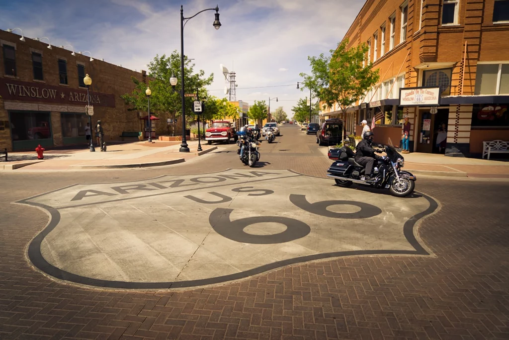 Motorradfahrer passieren das historische Route-66-Straßenschild im Zentrum von Winslow, Arizona.