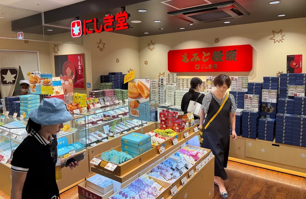 Japanischer Süßwarenladen Nishikidō mit bunten Geschenkboxen und Kunden.