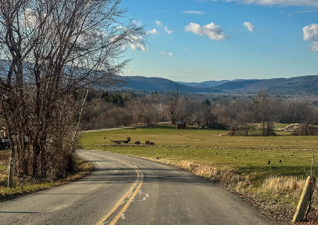 Kurvige Landstraße führt durch eine hügelige Farmlandschaft bei North Adams, Massachusetts, mit Blick auf den Mount Greylock.