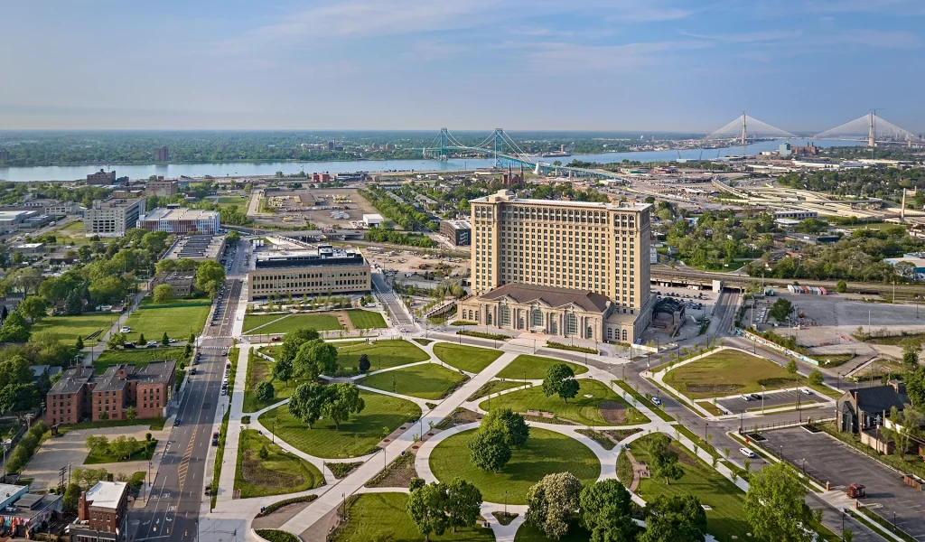 Luftaufnahme der renovierten Michigan Central Station mit umliegendem Park und Brücke.