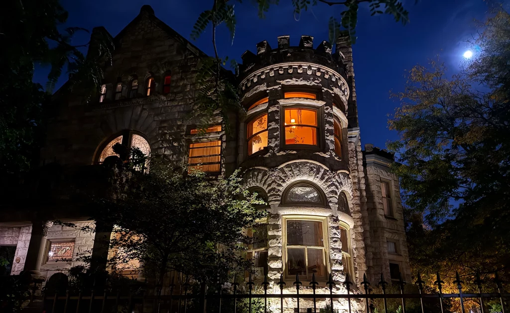 Historisches Steingebäude in Denver bei Nacht, dramatisch beleuchtet mit Vollmond am Himmel.