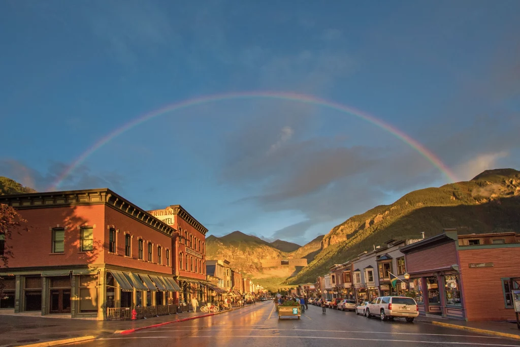 Regenbogen über der historischen Main Street von Telluride mit Bergen im Hintergrund.
