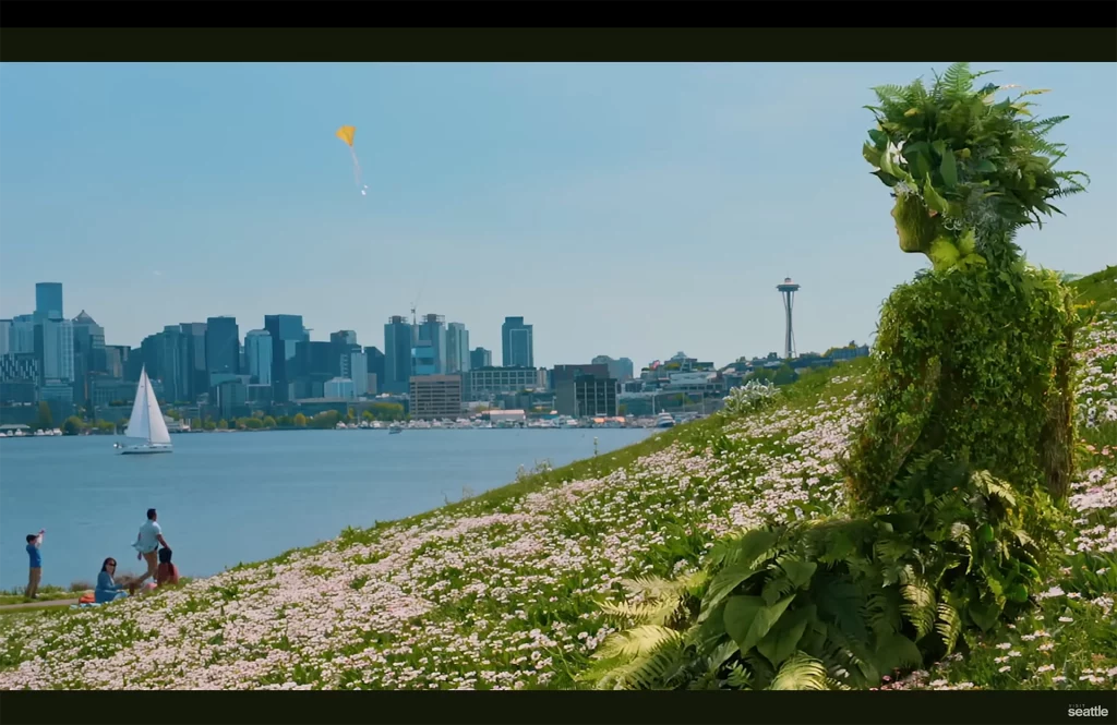 Blick vom Gas Works Park auf die Skyline von Seattle mit Space Needle, Segelbooten und grüner Wiesenlandschaft.