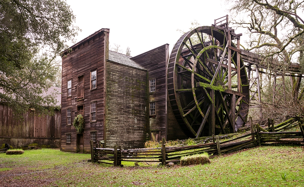 Historische Holz-Wassermühle mit großem Wasserrad im Bale Grist Mill State Historic Park in Napa Valley, Kalifornien.