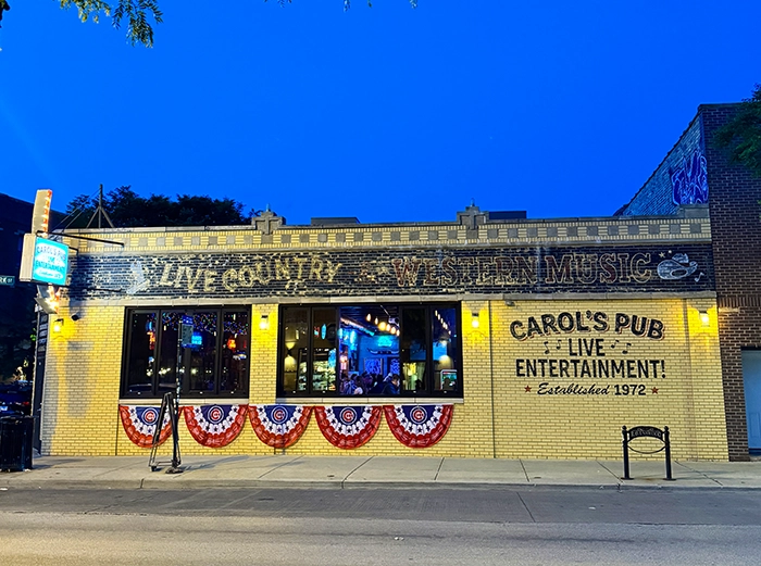 Carol’s Pub in Chicago bei Abenddämmerung – Fassade mit Leuchtschrift „Live Country Western Music“ und patriotischer Dekoration.