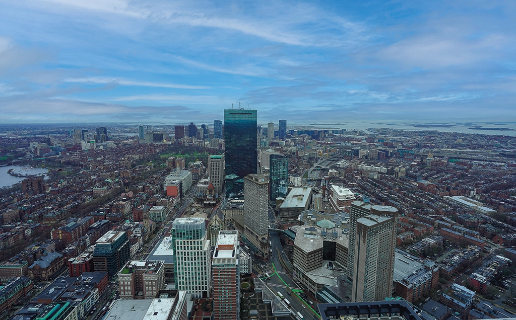 Blick über die Skyline von Boston mit Prudential Tower, Back Bay und Charles River bis zur Massachusetts Bay.