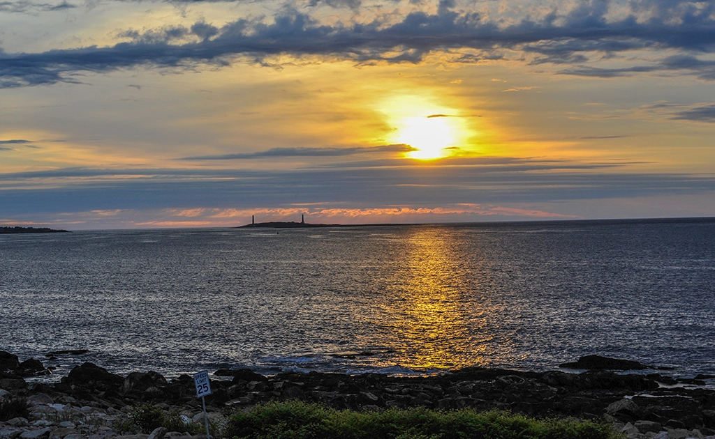 Sonnenaufgang über dem Atlantik mit Blick auf die Zwillingsleuchttürme von Thatcher Island vor Rockport, Massachusetts.