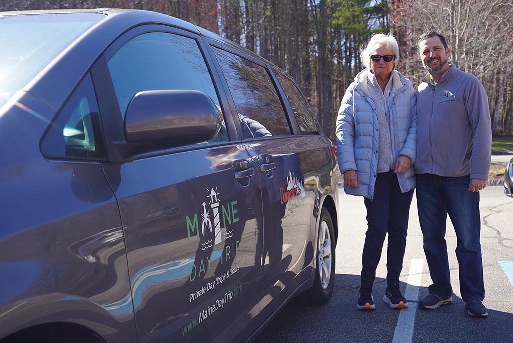 Steve Grasso von North American Traveler und Tour Guide Pam neben einem Maine Day Trip Van in Neuengland.