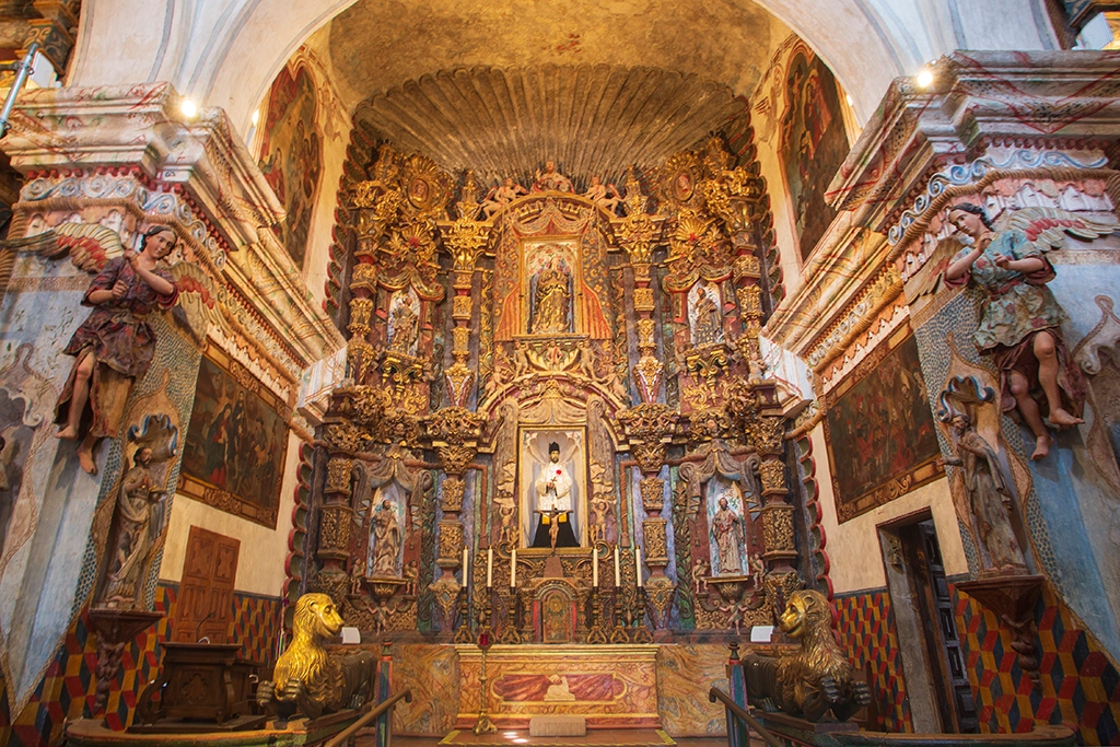 Interior of Mission San Xavier del Bac with ornate Spanish colonial altar.