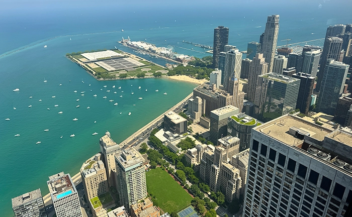 Blick von einem Hochhaus in Downtown Chicago auf den türkisblauen Lake Michigan mit dem berühmten Navy Pier und Segelbooten im Wasser.