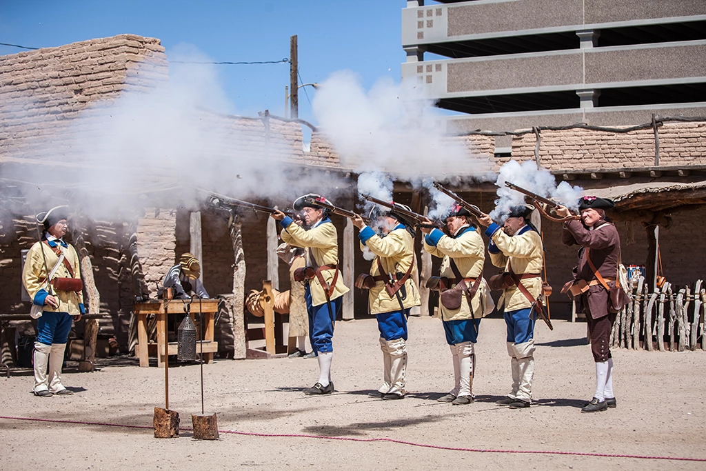 Historical reenactors firing muskets at Presidio San Agustín del Tucson.