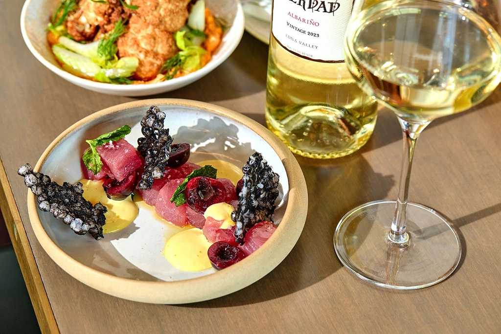 Vorspeise mit Thunfisch, Kirschen und knusprigen Chips, serviert mit Weißwein im The Block at Woods Hill in Boston.