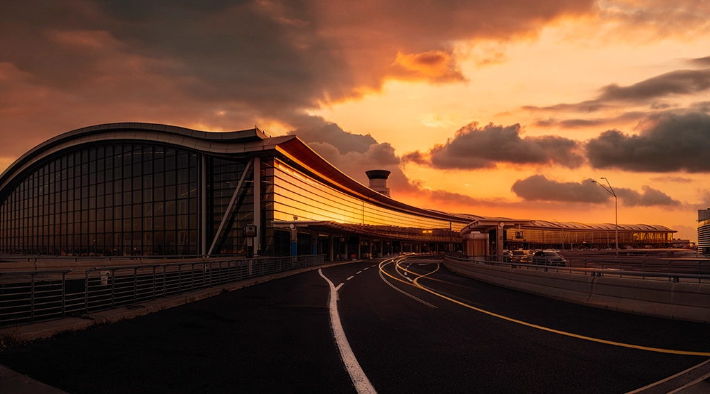 Glasfassade des Toronto Pearson Terminals im Licht eines dramatischen Sonnenuntergangs.
