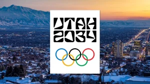 Utah-2034-Logo vor der verschneiten Skyline von Salt Lake City bei Sonnenuntergang