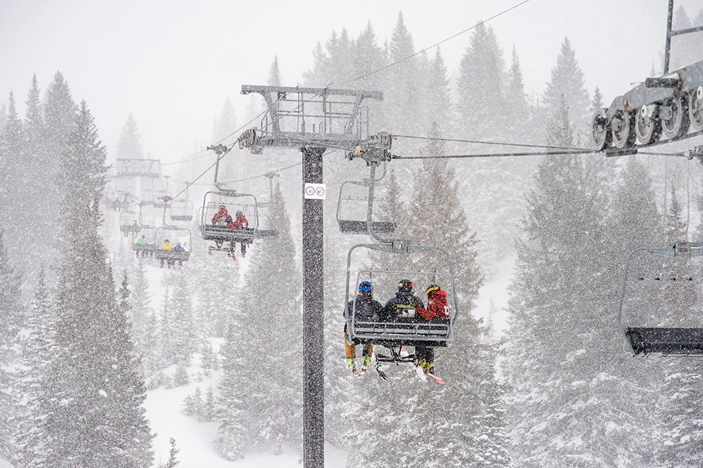 Skifahrer auf einem Sessellift im dichten Schneefall in einem Skigebiet in Utah