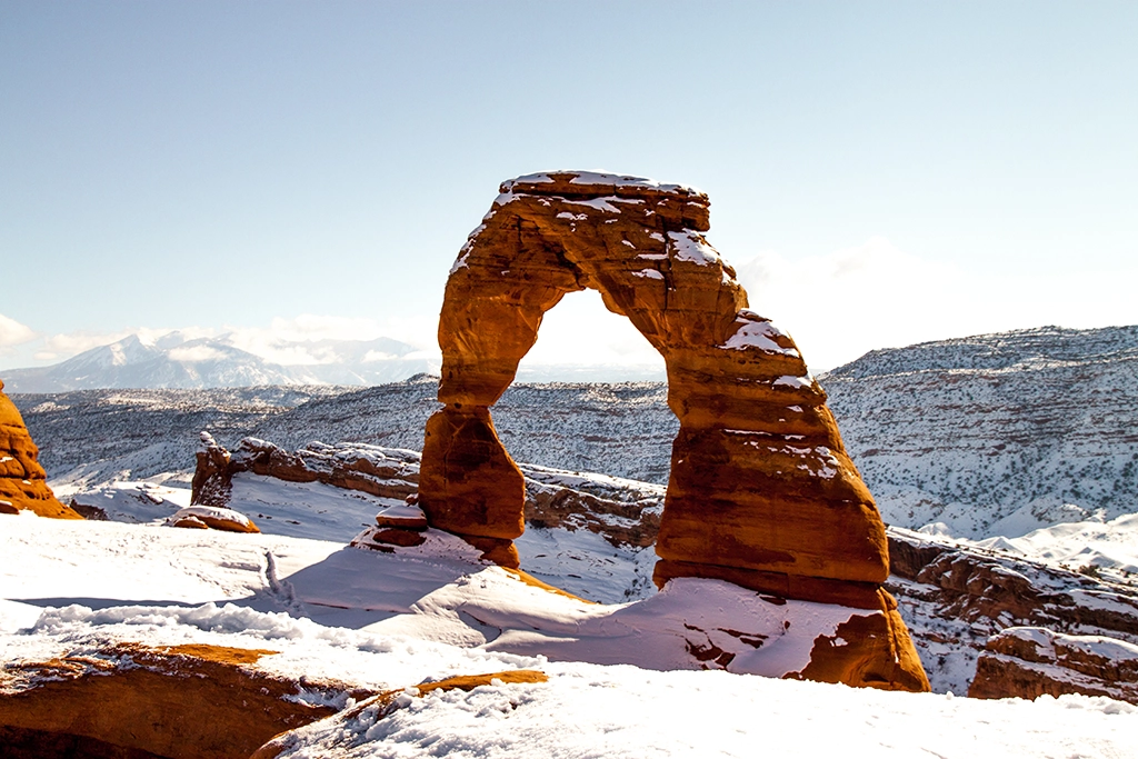 Der berühmte Delicate Arch im Arches Nationalpark, Utah, eingerahmt von Schnee und Winterlandschaft.