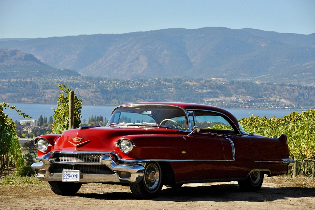 Nahaufnahme der Front eines roten Cadillac Oldtimers mit Blick auf den Okanagan Lake