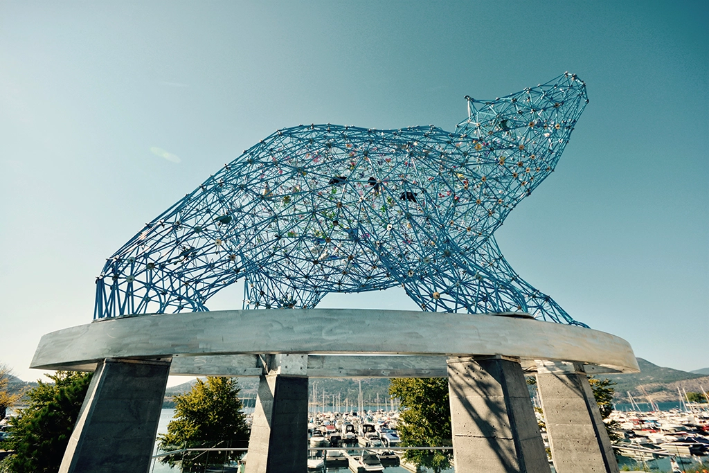 Blaue Metallskulptur eines Bären am Waterfront Park in Kelowna