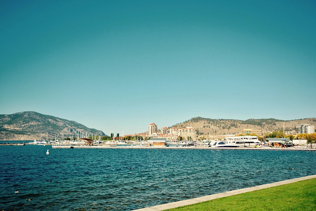 Blick auf die Kelowna Waterfront-Marina mit Booten, See und Bergen im Hintergrund