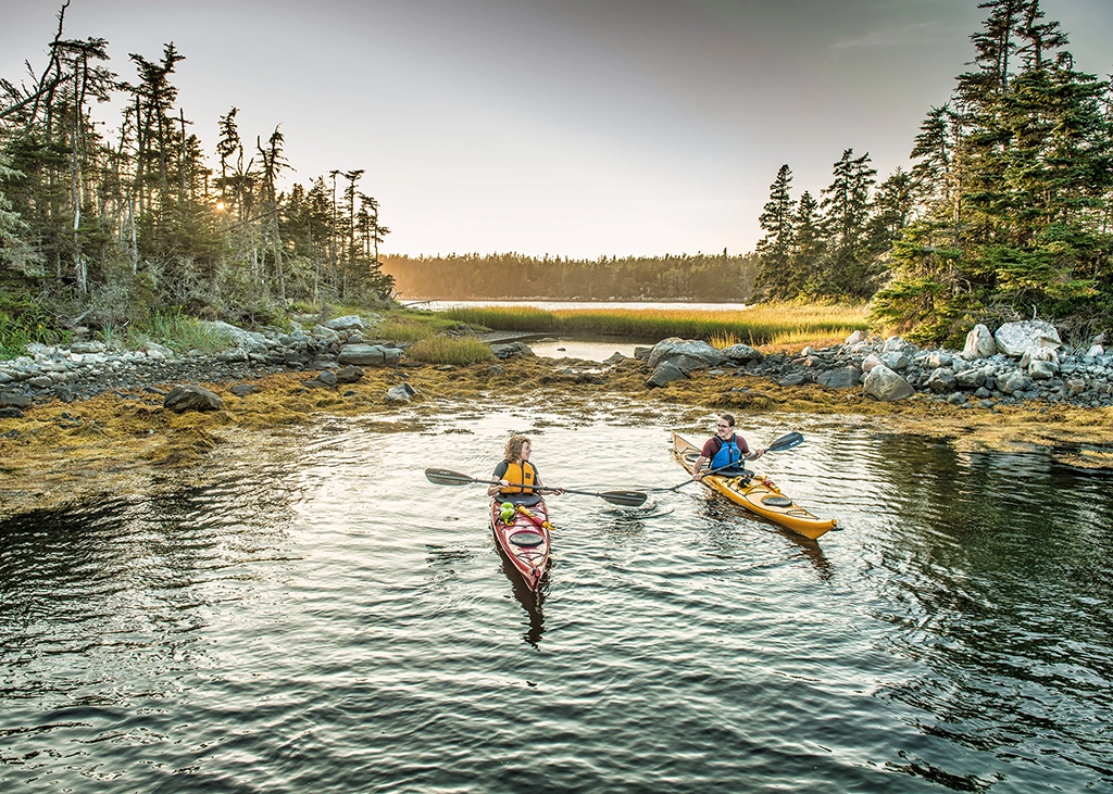 Zwei Personen im Seekajak bei Sonnenuntergang an der Eastern Shore in Nova Scotia