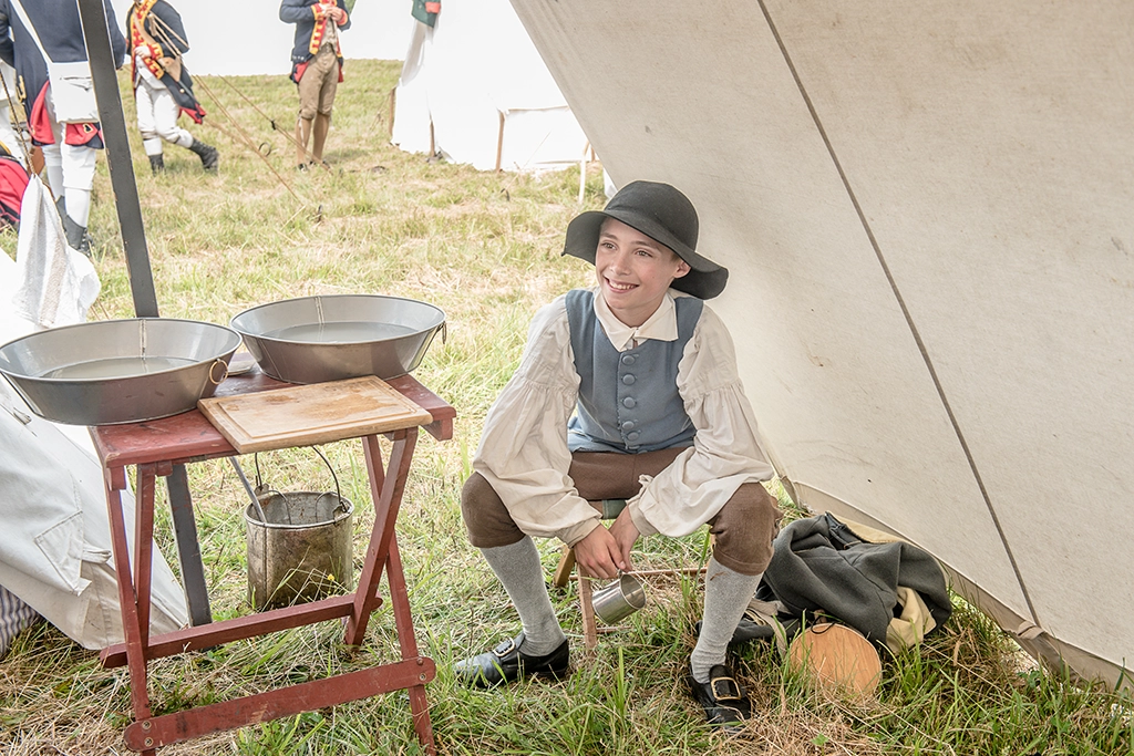 Junger Reenactor in historischer Kleidung vor einem Zelt am Hubbardton Battlefield in Vermont