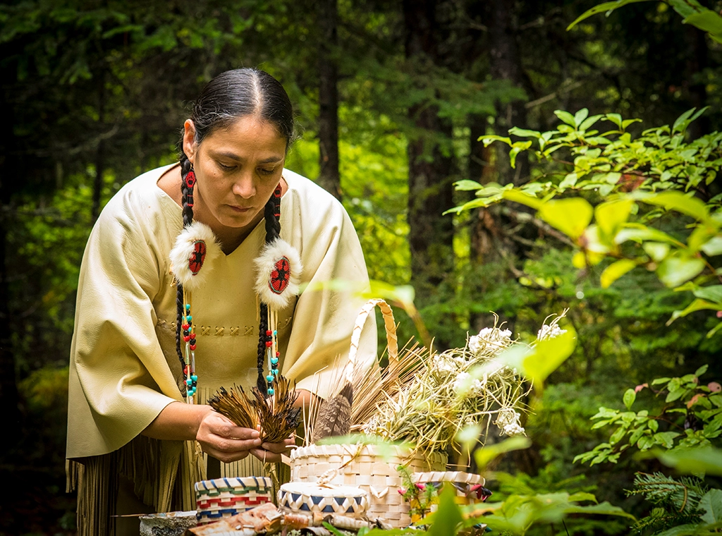 Mi’kmaq-Frau bei traditioneller Handwerksarbeit mit Naturmaterialien im Wald