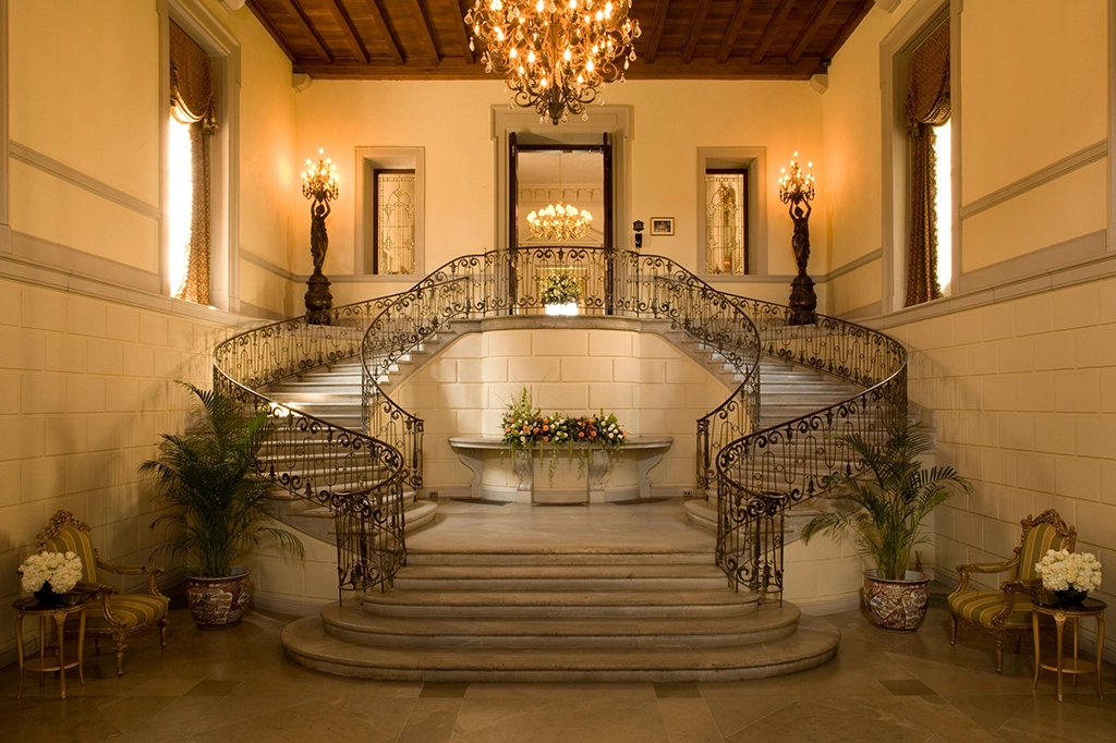 Große Marmortreppe mit kunstvollen Geländern im historischen Foyer des Oheka Castle