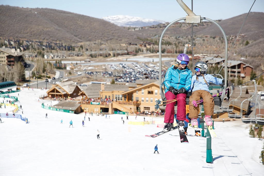 Zwei Kinder fahren gemeinsam auf einem Sessellift im familienfreundlichen Deer Valley Resort, Utah