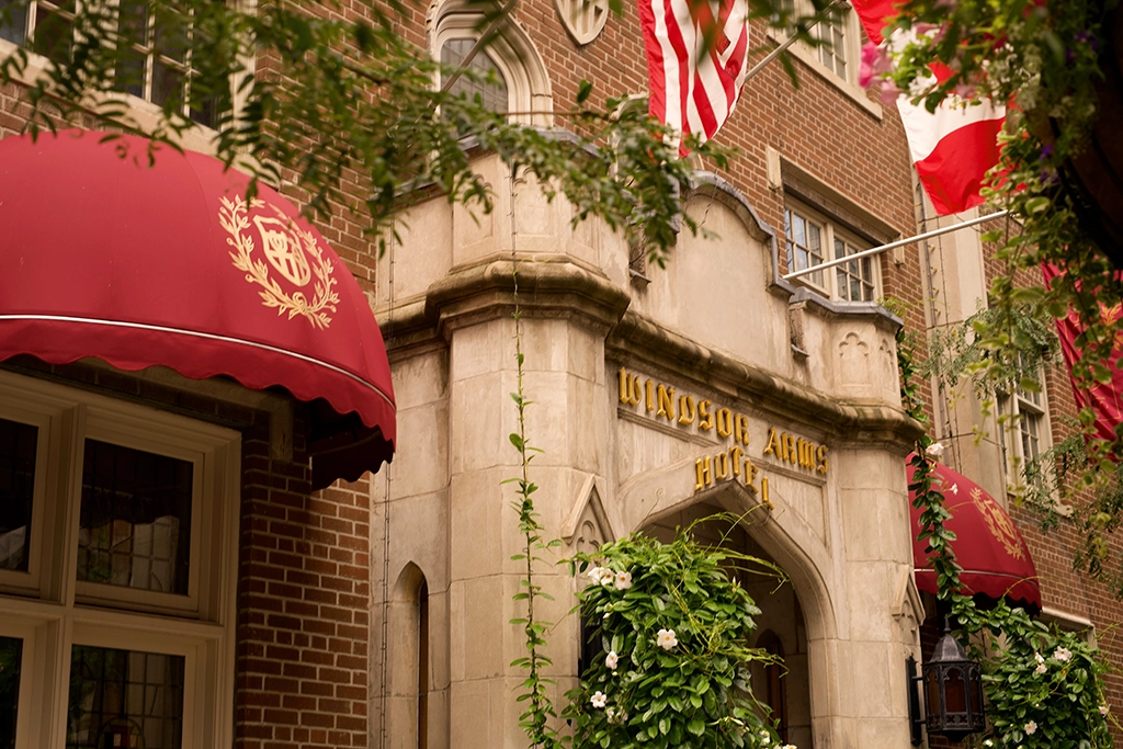 Neogotische Außenfassade des Windsor Arms Hotel mit rotem Baldachin und Blumenschmuck in Toronto.