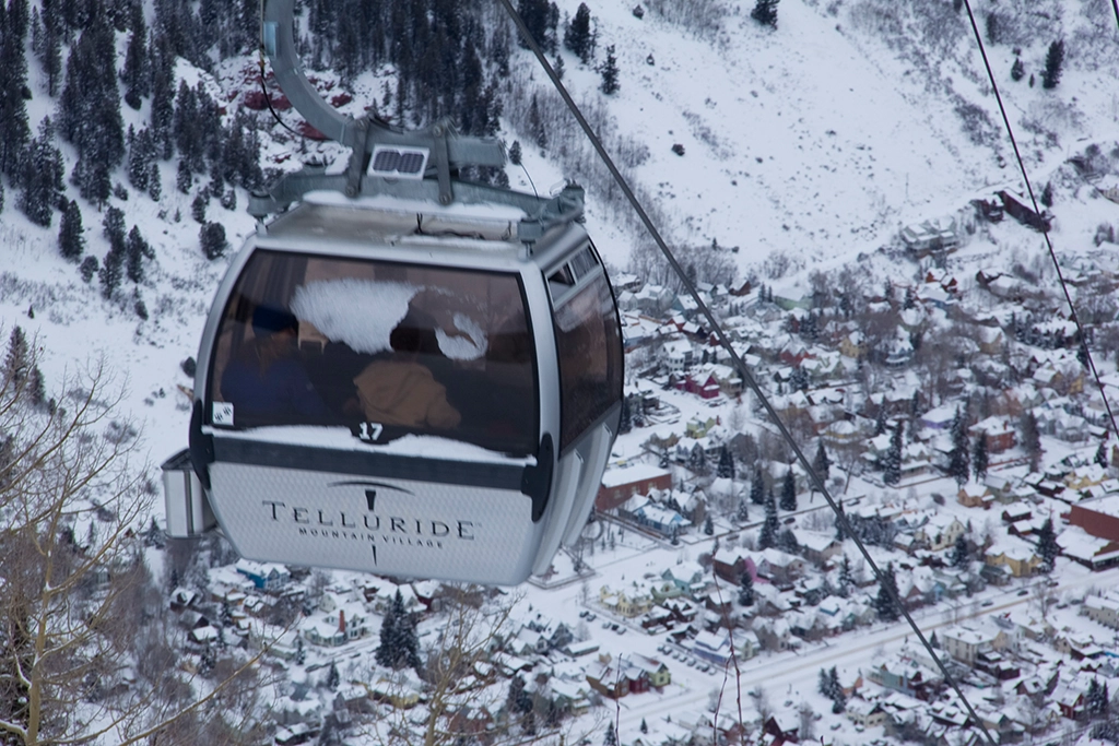 Gondelbahn schwebt über der verschneiten Bergstadt Telluride in Colorado