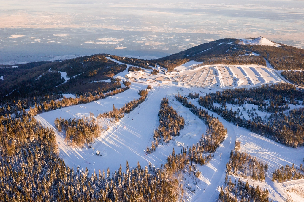 Luftaufnahme des Skigebiets Le Massif de Charlevoix mit Pisten und bewaldeten Hängen