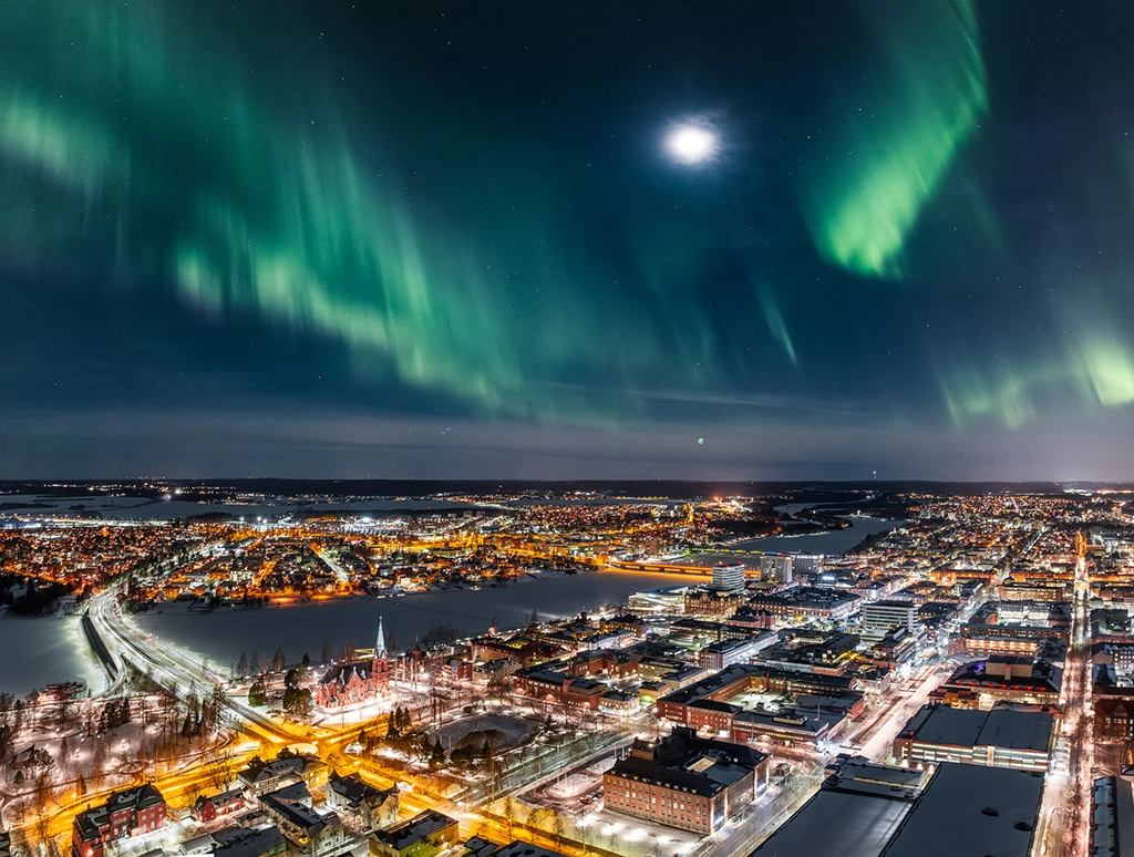 Grüne Nordlichter über der Stadt Luleå in Nordschweden.
