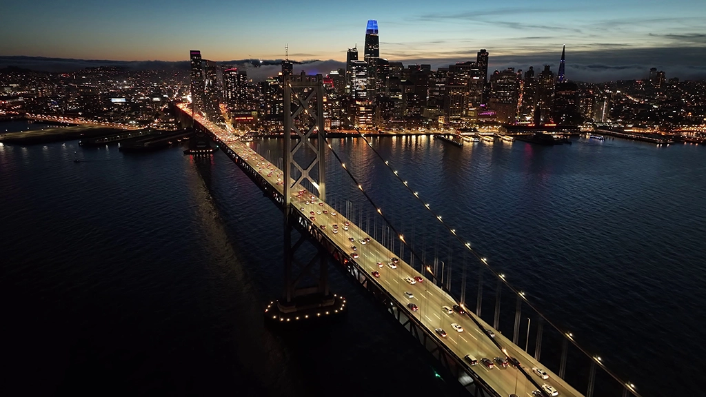 San Francisco bei Nacht mit Bay Bridge und beleuchteter Skyline aus der Luft