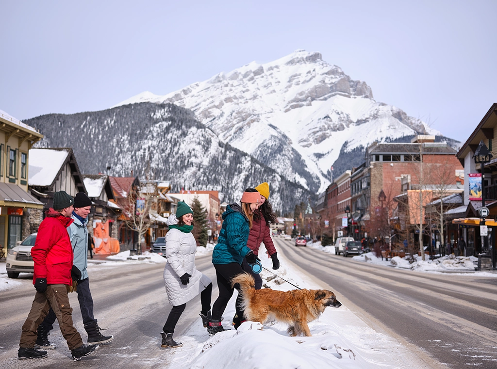 Winterliche Straßenszene mit Passanten und Hund in der Innenstadt von Banff