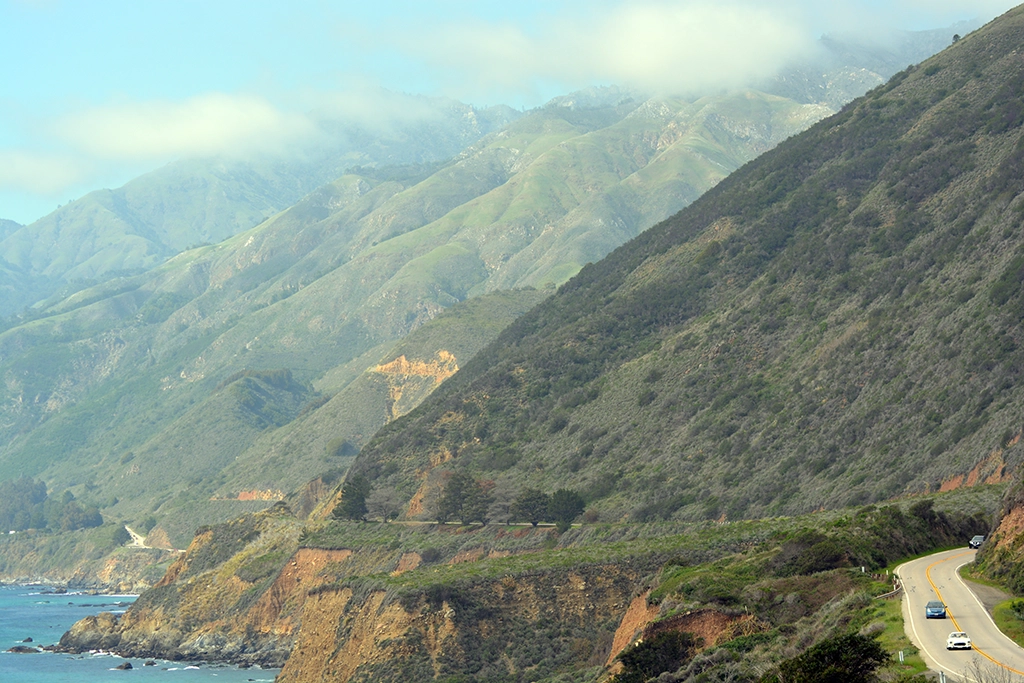 Serpentinenstraße des Highway 1 windet sich entlang der grünen Felsklippen in Big Sur, Kalifornien