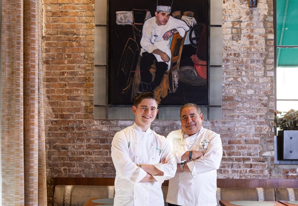 Koch Emeril Lagasse und sein Sohn E.J. Lagasse im Restaurant Emeril’s vor Backsteinwand und Porträt