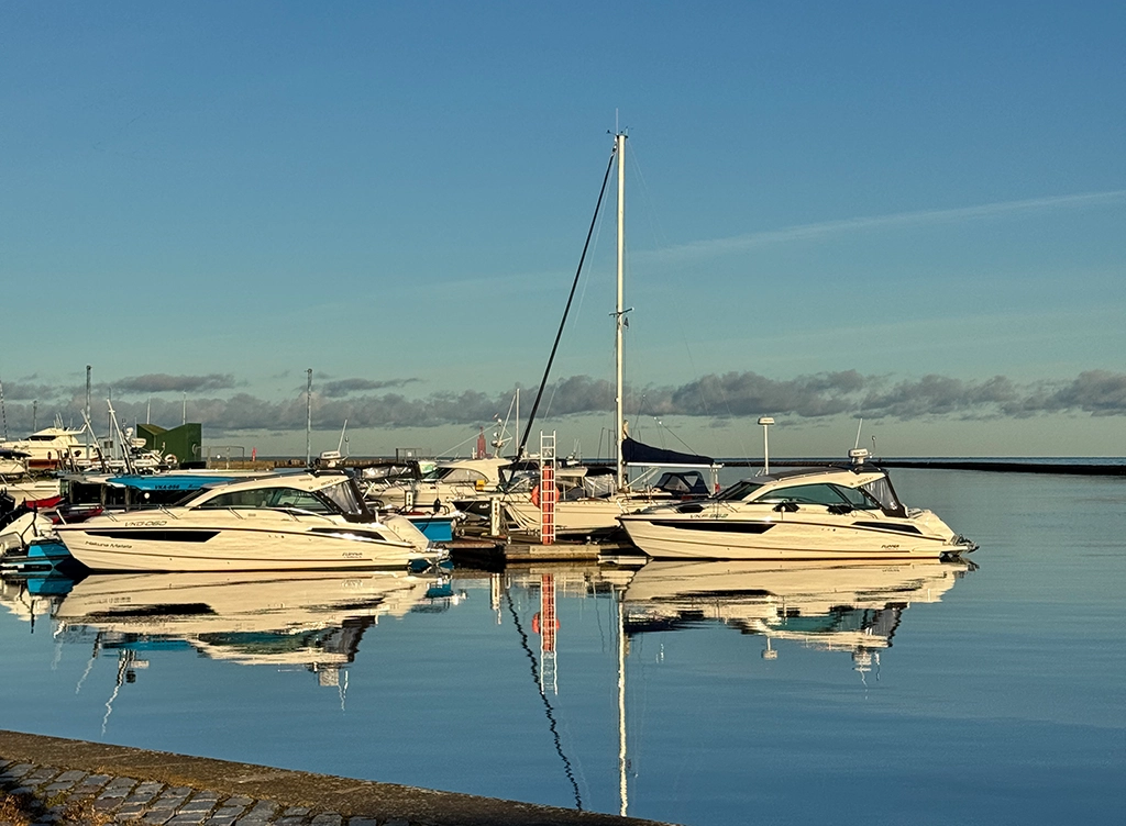 Sportboote liegen ruhig im Hafenbecken der Pirita Top Marina in Tallinn, spiegelglattes Wasser am frühen Morgen