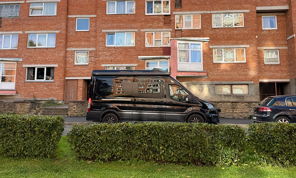 Campervan geparkt vor sowjetischem Wohnblock in Sillamäe, Estland