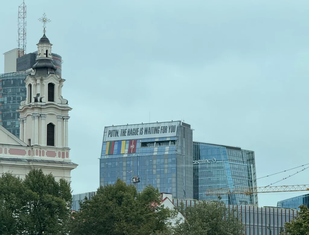 Moderne Gebäude in Vilnius mit politischem Banner vor historischer Kirche