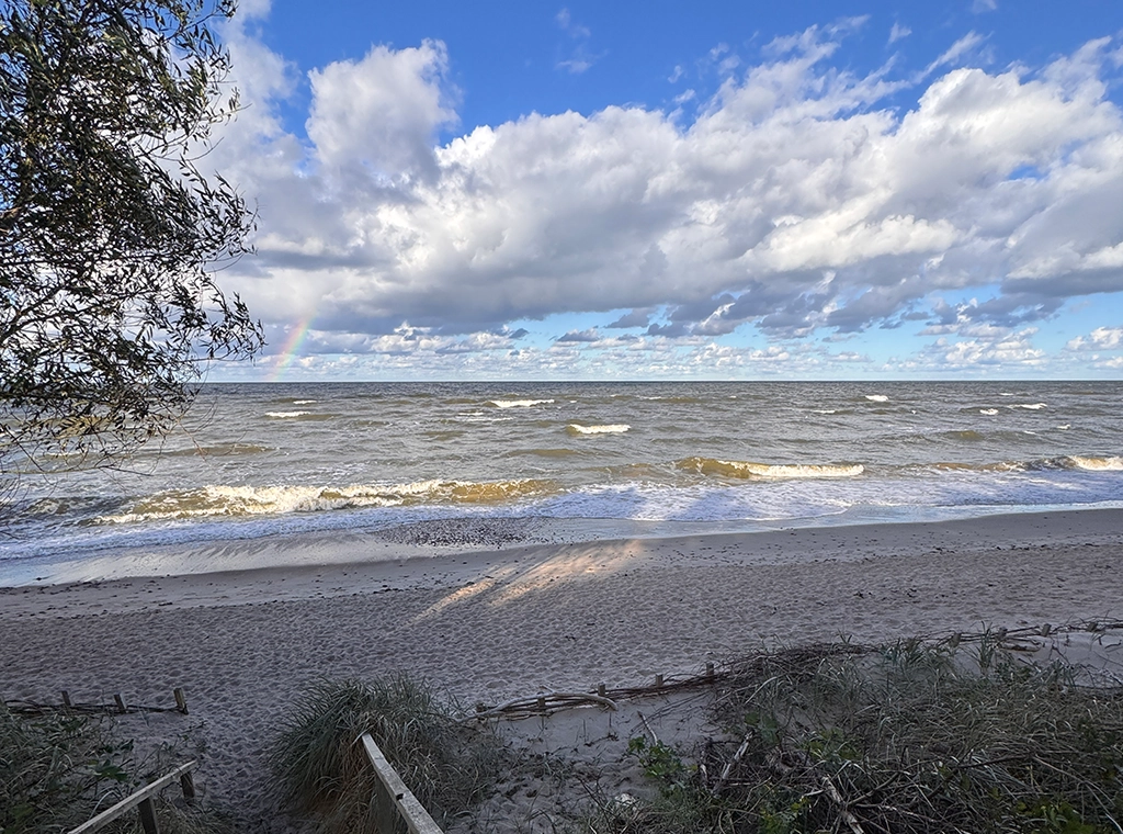 Herbststrand an der Ostsee bei Karklė in Litauen mit Wellen und Regenbogen